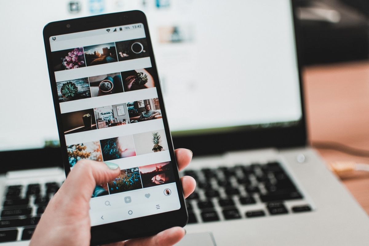 Човек държи смартфон с галерия от изображения, показвани в Instagram - вид социални медии