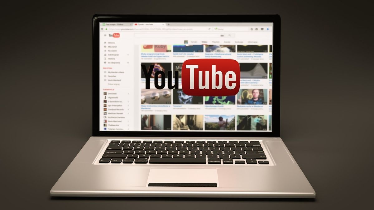 Сребърен лаптоп отворен с показана начална страница на YouTube
