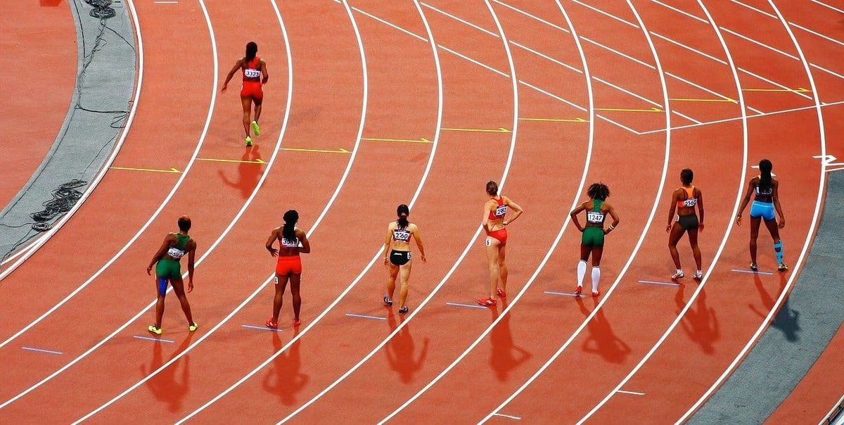 ocho atletas que se preparan para correr en una pista de atletismo
